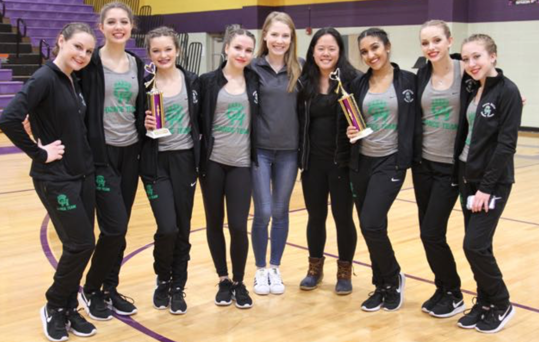 the dance team holding their district trophies